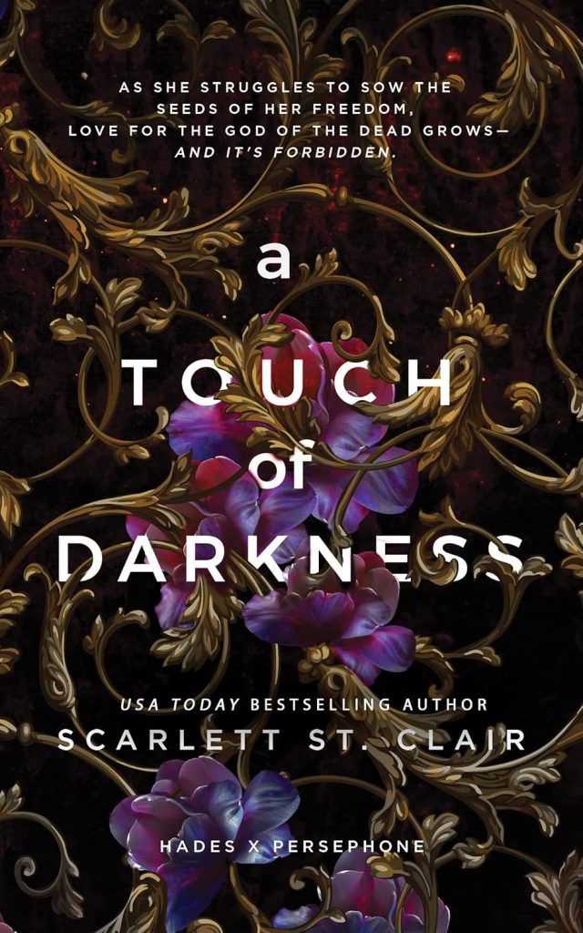 The book cover for "A Touch of Darkness" by Scarlett St. Clair features ornate gold vines and purple flowers over a dark background. The mood is mystical and alluring.