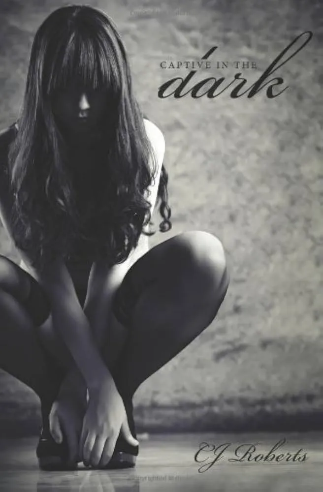 A woman in black stockings and heels crouches down, showcasing a stylish and confident pose.